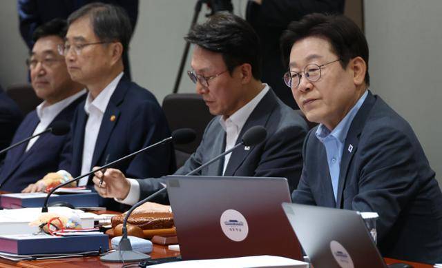 이재명 대통령이 12일 서울 용산 대통령실 청사에서 열린 국무회의에서 국무위원들을 바라보고 있다. 이 대통령 자리에 광복 80주년 기념 태극기 달기 캠페인 열쇠고리와 네임택이 놓여 있다. 뉴시스