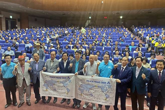 12일 오후 2시 전북도청 공연장에서 열린 '신통일한국 피스로드 2025 전북도 통일대장정' 행사에서 주요 참석자들이 서명한 피스로드 배너를 들고 파이팅을 외치고 있다. 전주=김동욱 기자
