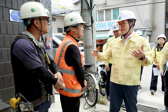 정원오(오른쪽) 서울 성동구청장이 성수동의 한 공사 현장에서 중국인 노동자 김수광(왼쪽)씨와 이수남씨에게 QR코드에 대해 묻고 있다. 성동구 제공