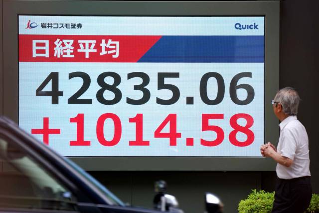 닛케이지수가 사상 최고치를 경신한 12일 일본 도쿄에서 한 남성이 닛케이지수 전광판을 바라보고 있다. 연합뉴스 외신사진