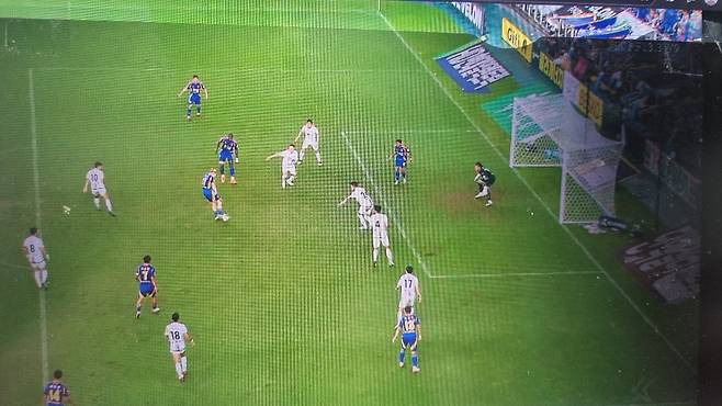 Ulsan Rubicson is shooting. Ulsan Eric is a player in the blue uniform in front of the goalkeeper on the right. Eric is in an offside position. Coupang Play Screen Capture