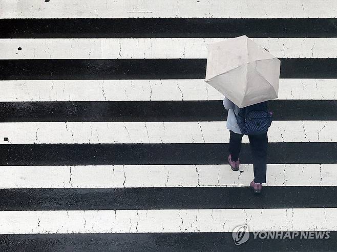 우산 쓰고 (울산=연합뉴스) 김용태 기자 = 울산에 비가 내린 12일 울산시 남구 한 거리에서 시민이 우산을 쓰고 횡단보도를 건너고 있다. 2025.8.12 yongtae@yna.co.kr