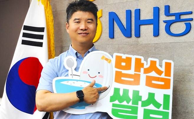 ▲ 이덕주 농협 포천시지부장이 '밥심 쌀심' 피켓을 들고 쌀 소비 촉진 캠페인에 적극 동참해달라며 환하게 웃고 있다.