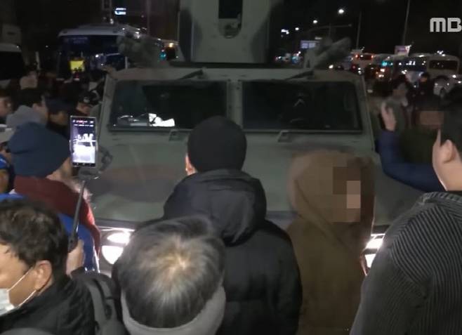 지난해 12월 3일 윤석열 전 대통령이 계엄을 선포한 뒤 국회로 향하는 장갑차를 막아선 시민들의 모습. (사진=MBC 뉴스 캡처)