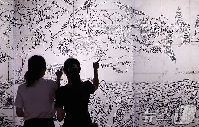 13일 서울 종로구 국립고궁박물관 2층 기획전시실에서 열린 특별전 '창덕궁의 근사謹寫한 벽화' 언론 공개회에서 참석자들이 최초 공개된 김은호의 백학도 초본(정본을 완성하기 전 그린 밑그림)을 살펴보고 있다. 국립고궁박물관은 14일부터 개관 20주년 특별전 '창덕궁의 근사謹寫한 벽화'에서 창덕궁 내전인 희정당, 대조전, 경훈각을 장식했던 벽화 6점을 최초로 일괄 공개한다. 2025.8.13/뉴스1 ⓒ News1 박지혜 기자