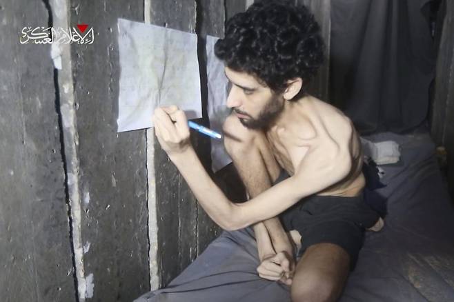 팔레스타인 무장단체 하마스가 지난 1일(현지시간) 공개한 촬영 날짜 미상의 영상에서 이스라엘 인질 에바아타르 데이비드가 본인이 억류된 가자지구 지하 터널 안에서 달력에 받은 음식을 표시하고 있다. 데이비드는 2023년 10월 7일 하마스의 기습 당시 납치됐다.AP뉴시스