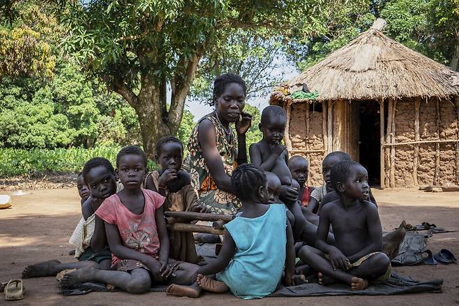 올해 6월26일(현지시각) 남수단 문드리 웨스트 카운티 코토비에서 다섯자녀를 둔 보비아 카와자(34)이 자신의 자녀와 이웃 아이들과 함께 집 밖에 앉아있다. 문드리웨스트/AP 연합뉴스