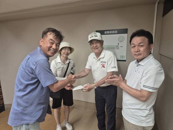 최동원기념사업회 강진수 사무총장(왼쪽)이 13일 여름 고시엔 현장을 찾아 교토국제고 관계자들에게 소정의 후원금을 전달하고 있다. 맨 오른쪽이 교토국제고 백승환 교장. 사진 강진수