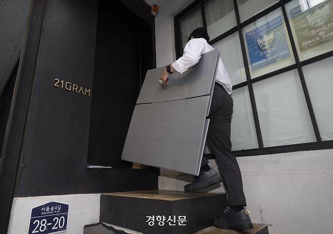 김건희 여사의 각종 의혹을 수사하는 민중기 특별검사팀이 대통령 관저 이전 문제를 주도했던 인테리어 업체 ‘21그램’에 대한 압수수색을 한 13일 서울 성동구 21그램 사무실로 박스를 가지고 들어가고 있다. 한수빈 기자