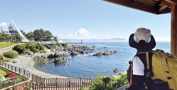 해파랑길 3코스는 임랑해수욕장에서 대변항까지 해안 길이 이어지나 기장군청 전·후 일부 구간은 도로를 걷거나 봉대산을 타는 산길이 포함된다. 해파랑길 1~3코스 지킴이인 김윤옥 씨가 신평소공원을 지나 나오는 정자 쉼터에서 휴식을 취하며 멀리 임랑해수욕장에서 걸어온 해안을 보고 있다. 가까이는 배 조형물 전망대인데 일부 철거되어  이제 두 기둥만 남아 있다.