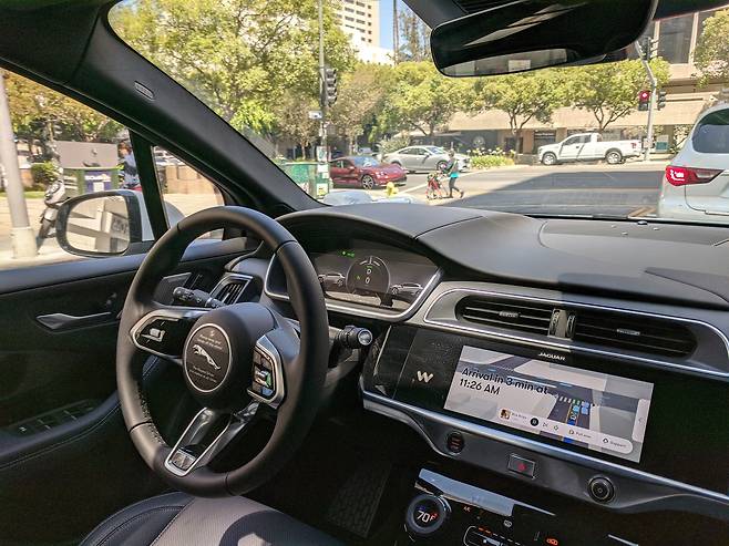 운전자 없는 웨이모(Waymo) 자율주행 라이드 셰어링(ride sharing). 차가 필자를 태우고 목적지로 이동 중에 앞차가 움직이기를 기다리고 있다.  차량 대시(dash)판에는 도착 예정 시간을 계속 업데이트 해준다. 웨이모 자율주행차는 앞 차의 ‘뒷 타이어가 땅을 닫는곳’이 보이는 안전한 거리를 유지하며 주행한다.  사진: @강형원 촬영