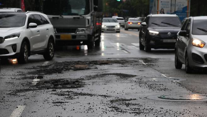 13일 인천 계양구 작전동의 일부 도로가 침수로 균열이 생겨 차량이 우회하고 있다. [연합]