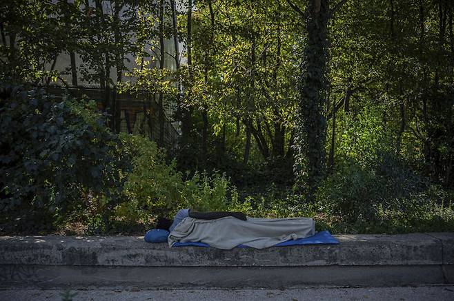[파리=AP/뉴시스] 12일(현지 시간) 프랑스 파리에서 한 노숙자가 그늘 아래서 잠을 자고 있다. 2025.08.13.