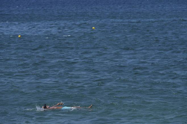 [아테네=AP/뉴시스] 12일(현지 시간) 그리스 아테네 글리파다 해변에서 한 남성이 수영을 하고 있다. 2025.08.13.
