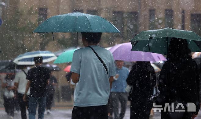 [서울=뉴시스] 김선웅 기자 = 서울에 호우주의보가 내려진 13일 서울 종로구 세종대로에서 우산을 쓴 시민들이 길을 걷고 있다. 2025.08.13. mangusta@newsis.com