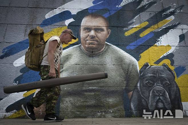[키이우=AP/뉴시스] 지난 6월4일(현지 시간) 우크라이나 키이우에 '거미집(스파이더웹) 작전'을 지휘한 바실 말류크 보안국(SBU) 국장 벽화 앞으로 한 남성이 지나가고 있다. 2025.08.13.