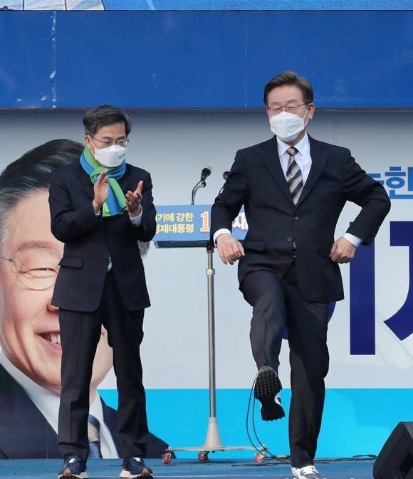 2022년 3월3일&nbsp;이재명 당시 민주당 대선 후보가 서울 영등포&nbsp;타임스퀘어&nbsp;광장에서 집중 유세를 벌이던 중 김동연 전 새로운물결 후보로부터 선물 받은 운동화를 신어보고 있다. 국회사진취재단