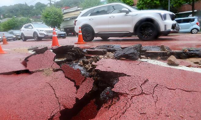 13일 서울 종로구 한 도로에 땅 꺼짐 현상이 발생해 교통이 통제되고 있다. 연합뉴스