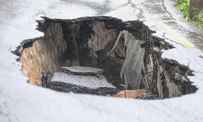 13일 서울 강북구 도선사 진입로에 집중호우로 인한 땅 꺼짐 현상이 발생해 도로가 무너져 있다. 연합뉴스