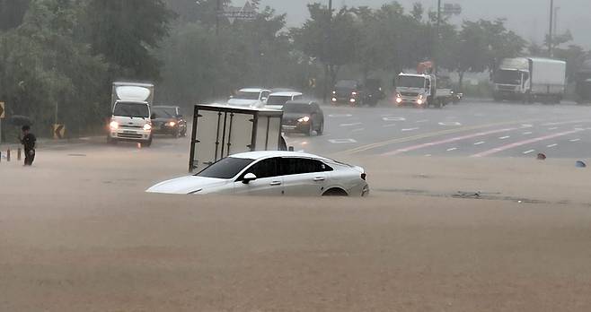 수도권에 많은 비가 내린 13일 경기도 고양시 덕양구 화랑로에서 차량이 침수되자 운전자가 밖으로 나오고 있다. 독자 제공·연합뉴스