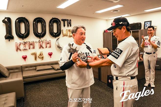 김경문 한화 감독이 12일 대전 롯데전에서 감독 1000승을 달성한 뒤 코칭스태프로부터 기념 선물을 받고 활짝 웃고 있다. 한화이글스 제공