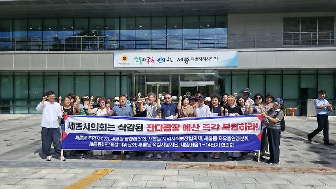 14일 시의회 청사 앞에서 잔디광장 예산의 정상화를 촉구하고 나선 새롬동 주민들. 사진=이희택 기자.