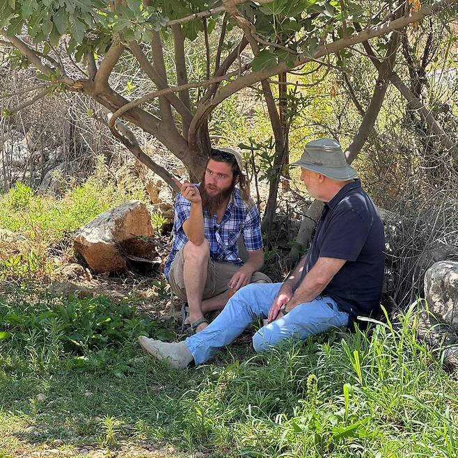 무화과나무 아래 풀밭에 앉아 있는 제레미 보웬과 메이어 심차
