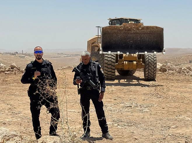 서안 지구 남부 움 알 카이르 근처 '카르멜 정착지' 확장 공사를 진행 중인 굴착기 주변에서 경계 근무를 서고 있는 경찰들의 모습