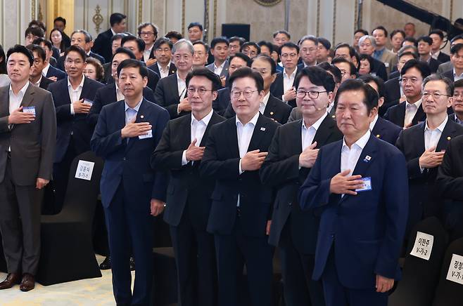 이재명 대통령, 김민석 국무총리 등 참석자들이 13일 청와대 영빈관에서 열린 국정기획위원회 국민보고대회에서 국기에 경례하고 있다. /연합뉴스