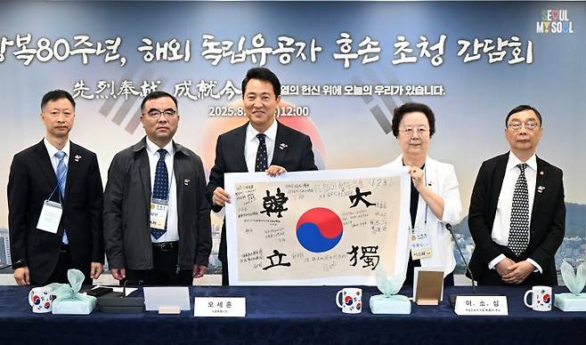 14일 서울시청에 열린 광복절 80주년 경축식에서 오세훈 서울시장과 독립운동가 후손들이 태극기에 서명하고 기념사진을 촬영하고 있다. 이날 오 시장을 비롯한 12인은 안중근 의사가 거사를 앞두고 12명의 동지와 함께한 '단지동맹'의 취지를 계승해 태극기에 서명하는 행사를 가졌다. 왼쪽부터 김은충 선생 외손자녀 정해씨, 삼부자 독립운동가로 유명한 '유기석 선생'의 손자 유화씨, 오세훈 서울시장, 이달 선생의 장녀 이소심 여사, 김구 선생의 주치의였던 '유진동 선생'의 아들 유수동씨 서울시 제공