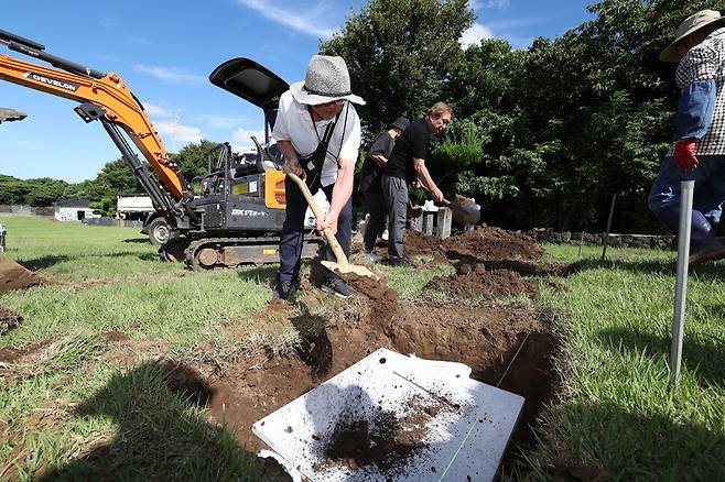 홍성민씨가 지난달 29일 오전 제주시 조천읍 와흘리 가족묘지에 안장된 조부모의 유골함 위로 흙을 뿌리고 있다. 제주/김영원 기자 forever@hani.co.kr