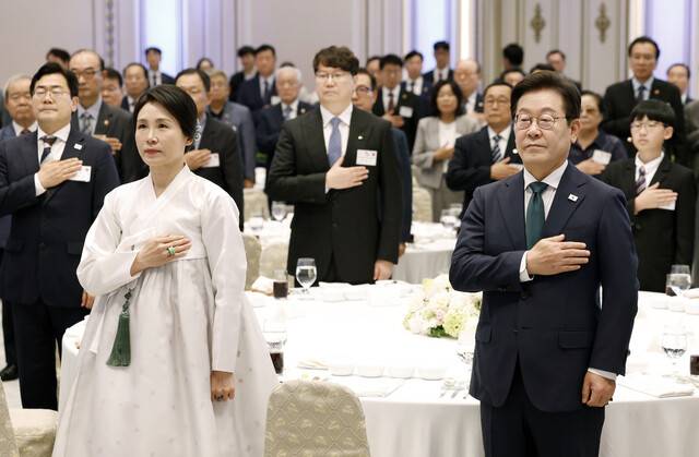 이재명 대통령과 김혜경 여사가 14일 청와대 영빈관에서 열린 ‘광복 80주년, 대통령의 초대’ 행사에서 참석자들과 국기에 경례하고 있다. 연합뉴스