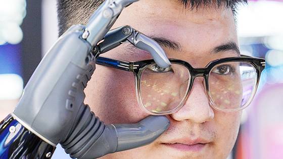 브레인코 직원이 지난달 17일 베이징에서 열린 제3회 중국 국제 공급망 박람회(CISCE)의 디지털 기술 구역에서 스마트 의수를 사용해 안경을 벗고 있다. 중국은 AI 기술을 적용한 제품을 쏟아내고 있다. 신화=연합뉴스