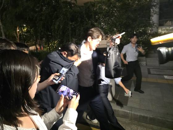 김건희 여사 오빠 김진우(55)씨가 증거인멸 혐의로 지난달 28일 소환조사를 받은 뒤 웃옷으로 얼굴을 가린 채 특검 사무실을 빠져나왔다. 이찬규 기자.