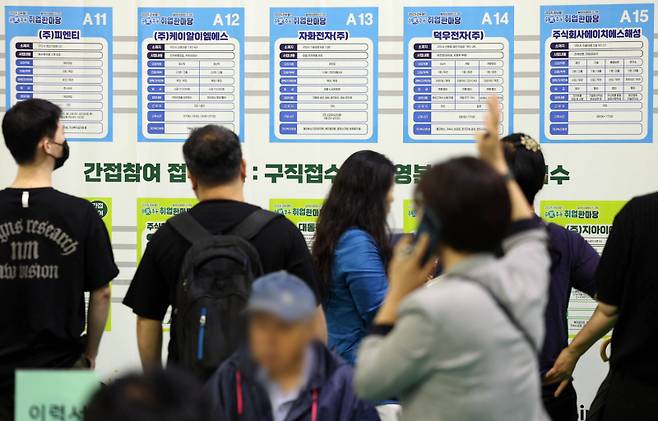 지난달 16일 오후 경북 구미시 복합스포츠센터에서 열린 ‘춘하추동 취업 한마당’에서 구직자들이 회사별 채용정보를 살펴보고 있다. 연합뉴스&nbsp;&nbsp;