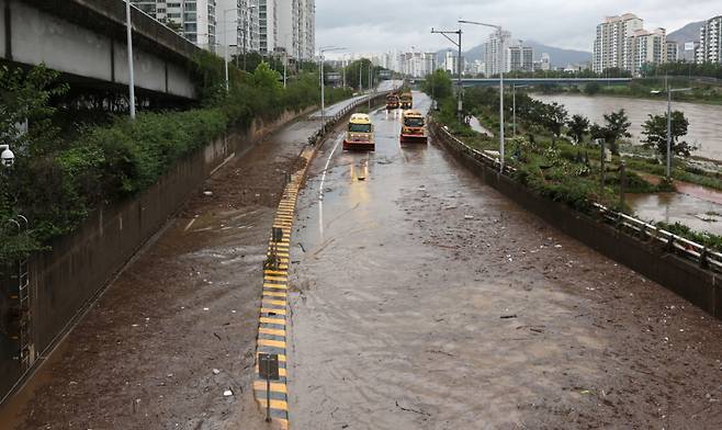 서울에 호우경보가 내려지고 중랑천에 홍수주의보가 발령된 13일 서울 노원구 중랑천 월릉교 인근 동부간선도로가 침수돼 복구작업이 진행되고 있다. /사진=뉴시스.