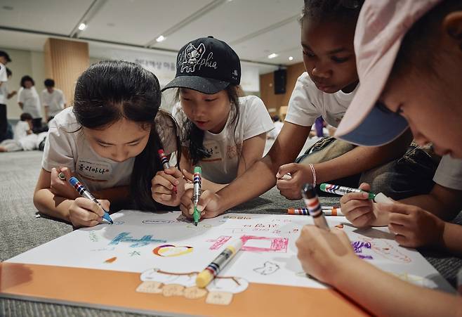 현대해상 천안사옥에서 열린 ‘마음한글’ 여름방학 프로그램 참여자들이 팀을 이뤄 그림을 그리고 있다. [현대해상 제공]