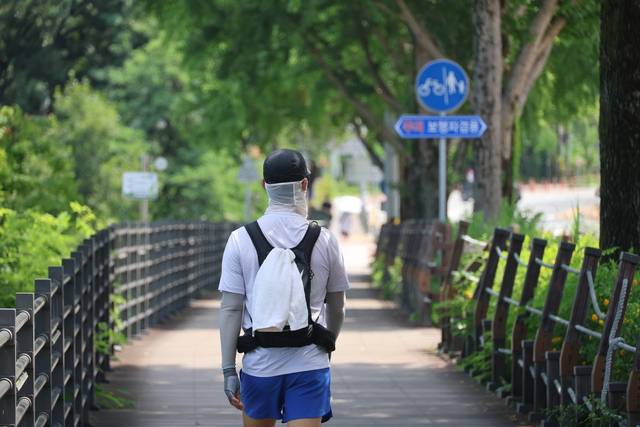 10일 대전 대덕구 대청댐 산책로를 찾은 시민이 걸으며 한여름의 정취를 즐기고 있다. 연합뉴스