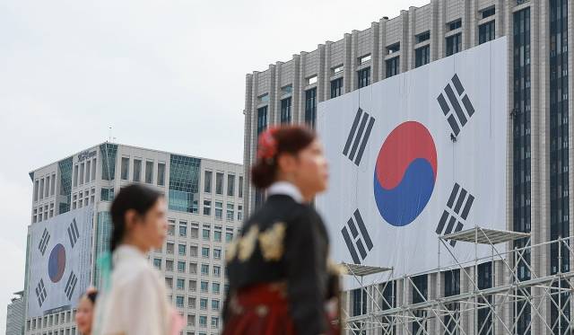 광복절을 나흘 앞둔 11일 정부서울청사(오른쪽) 외벽에는 대형 태극기가, 외교부에는 김구 서명문 태극기가 걸려 있다. 연합뉴스