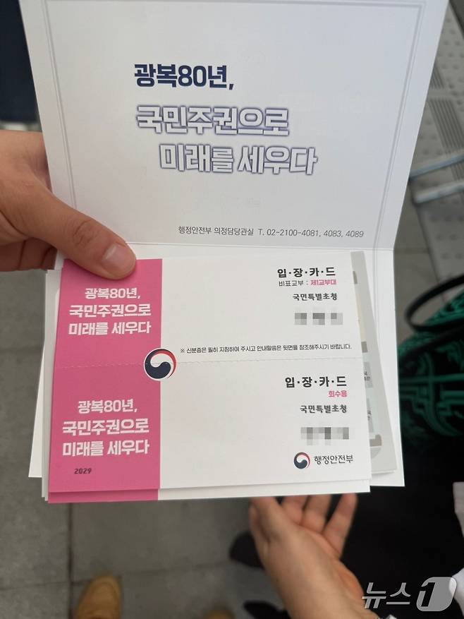 18일 오후 서울 광화문 광장에서 열린 제21대 대통령 국민임명식에 참석한 한 시민이 입장카드를 펼쳐 보이고 있다. 2025.8.15/뉴스1 권준언 기자