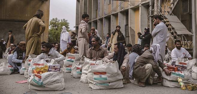 이란에서 추방된 아프가니스탄 난민이 8월 1일 카불에 있는 식량 배급소에서 물품을 받고 대기 중이다. /사진  EPA연합