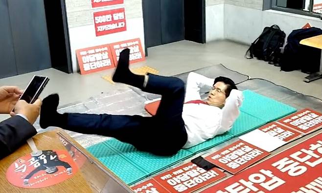 김문수 국민의힘 당 대표 후보가 15일 여의도 중앙당사 1층에서 무기한 농성 중 스트레칭을 하는 모습. 유튜브 김문수 티브이(TV) 갈무리