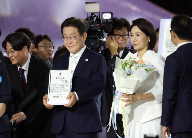 이재명 대통령이 15일 서울 종로구 광화문광장에서 열린 광복 80년, 국민 주권으로 미래를 세우다 제21대 대통령 국민임명식에서 국민 대표 80인이 참여한 임명장을 전달받고 있다. 뉴스1