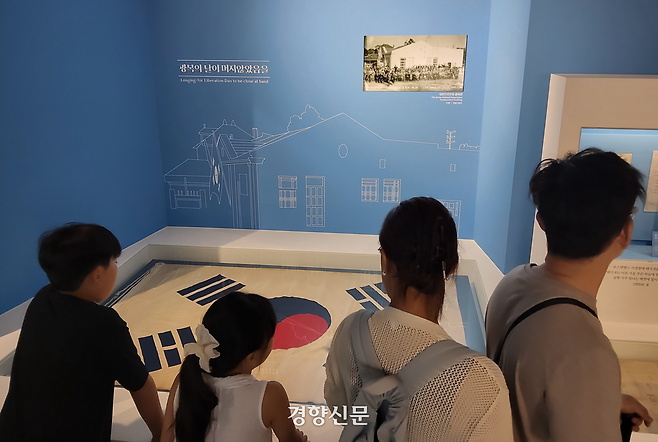 시민들이 80주년 광복절인 15일 서울 종로구 대한민국역사박물관을 찾아 일제강점기 만들어진 ‘대한인국민회 태극기’를 관람하고 있다. 이 태극기는 1910년 미국에서 조직된 독립운동단체 ‘대한인국민회’ 행사에서 사용된 것으로 추정된다. 김태욱 기자