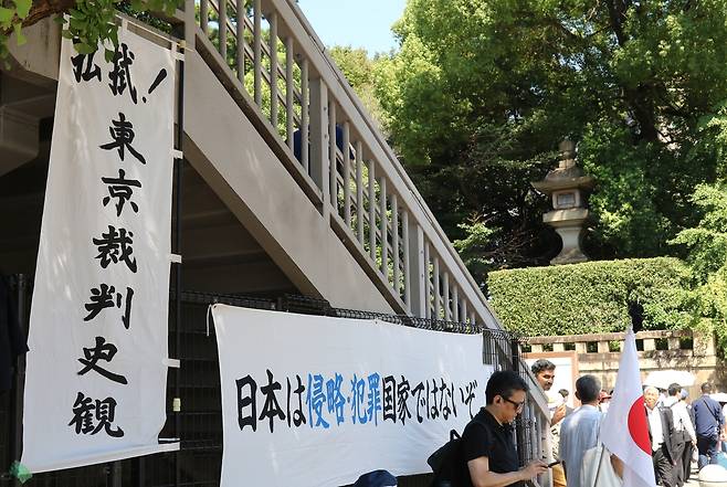 일본이 패전 80년을 맞은 15일 도쿄 야스쿠니신사 근처에 “일본은 침략·범죄 국가가 아니다”라는 현수막이 걸려 있다. 야스쿠니신사에는 태평양전쟁 A급 전범이 합사돼 있다. 연합뉴스