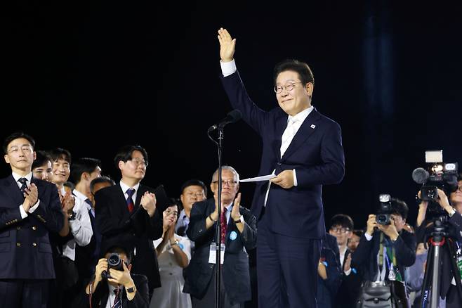 이재명 대통령이 15일 서울 광화문광장에서 열린 제21대 대통령 국민임명식 행사에서 감사 인사를 하며 손을 들어보이고 있다. 연합뉴스