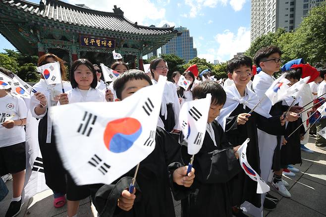 광복절을 하루 앞둔 14일 오후 대구 중구 국채보상운동 기념공원 종각 앞에서 국채보상운동 기념사업회 주최로 열린 광복 80주년 기념 플래시몹 퍼포먼스에서 참가자들이 태극기를 흔들고 있다. [연합]