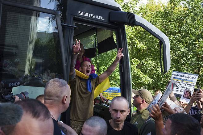 [체르느히우=AP/뉴시스] 14일(현지 시간) 우크라이나 체르느히우에서 러시아와 우크라이나 간 전쟁포로 교환으로 돌아온 우크라이나 군인이 버스에서 내리면서 구호를 외치고 있다. 러시아와 우크라이나는 도널드 트럼프 미국 대통령과 블라디미르 푸틴 러시아 대통령의 정상회담을 하루 앞두고 전쟁포로 84명을 각각 교환했다. 2025.08.15.