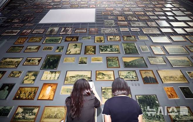 [부산=뉴시스] 하경민 기자 = 제80주년 광복절을 앞두고 11일 부산 남구 국립일제강제동원역사관에서 관람객들이 강제징용 피해자와 유족 등이 기증한 다양한 사진을 채운 벽면을 둘러보고 있다. 2025.08.11. yulnetphoto@newsis.com