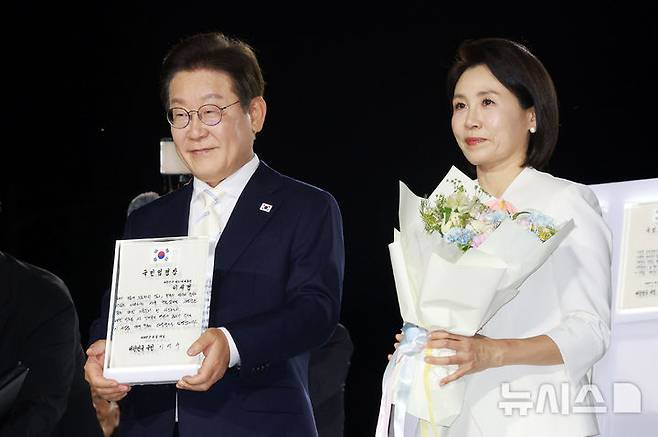 [서울=뉴시스] 고범준 기자 = 이재명 대통령이 15일 서울 세종대로 광화문광장에서 열린 제21대 대통령 국민임명식 '광복 80년, 국민주권으로 미래를 세우다' 행사에서 임명장을 들어 보이고 있다. 2025.08.15. bjko@newsis.com